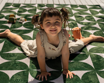 Non-toxic foam baby play mat in modern mid-century design – dark green and neutral tones in family living room